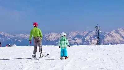 a man and a child on skis on a snow covered mountain at Holiday Home Julian Alps in Bovec
