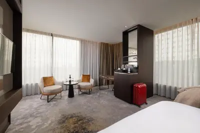 a hotel room with a bed and a table and chairs at InterContinental - Ljubljana by IHG in Ljubljana