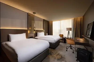 a hotel room with two beds and a desk at InterContinental - Ljubljana by IHG in Ljubljana