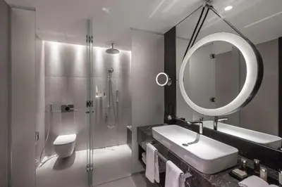 a bathroom with a sink and a shower and a mirror at InterContinental - Ljubljana by IHG in Ljubljana
