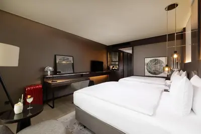 a hotel room with a large bed and a desk at InterContinental - Ljubljana by IHG in Ljubljana