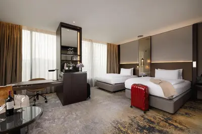 a hotel room with two beds and a desk at InterContinental - Ljubljana by IHG in Ljubljana