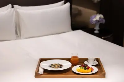 a tray with two plates of food on a bed at InterContinental - Ljubljana by IHG in Ljubljana
