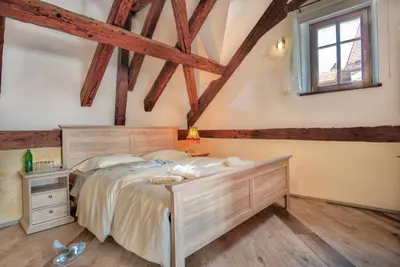 a bedroom with a large bed and a window at Hiša Linhart, Hotel & Restaurant in Radovljica