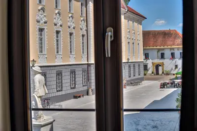 a view from a window of a building with a statue at Hiša Linhart, Hotel & Restaurant in Radovljica
