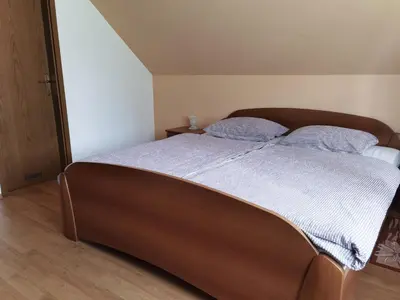 a bedroom with a large bed with two blue pillows at Gostišče Hedvika in Kal-Koritnica