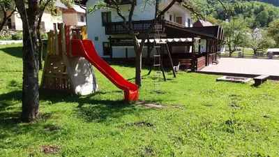 a red slide in a yard next to a house at Gostišče Hedvika in Kal-Koritnica