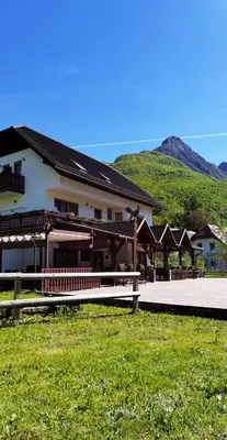 a building with a fence in front of it at Gostišče Hedvika in Kal-Koritnica