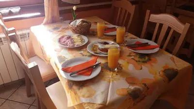 a table with plates of food and orange juice on it at Gostišče Hedvika in Kal-Koritnica