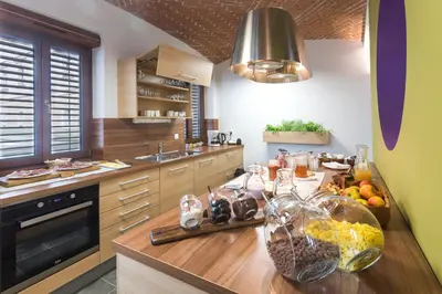 a kitchen with a wooden counter top with bowls of fruit at Hostel Bearlog Kočevje in Kočevje