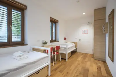 a hospital room with two beds and a desk at Hostel Bearlog Kočevje in Kočevje