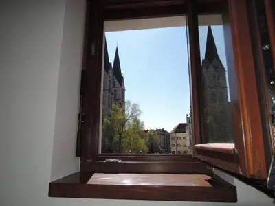 an open window with a view of a church at Hostel Bearlog Kočevje in Kočevje