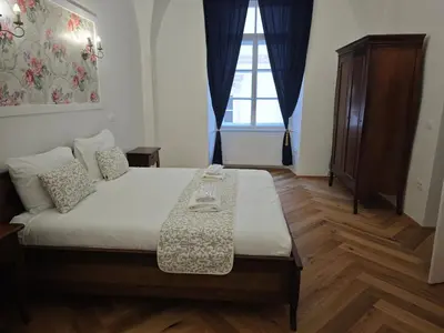 a bedroom with a bed with a table on it at Barbo Palace Apartments and Rooms in Ljubljana