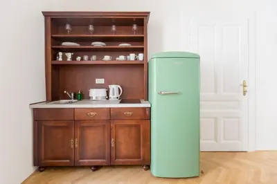 an old refrigerator in a kitchen next to a cabinet at Barbo Palace Apartments and Rooms in Ljubljana