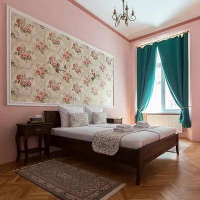 a bedroom with a bed with a painting on the wall at Barbo Palace Apartments and Rooms in Ljubljana