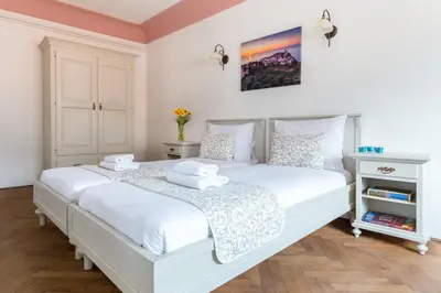 a bedroom with a large white bed with white sheets at Barbo Palace Apartments and Rooms in Ljubljana