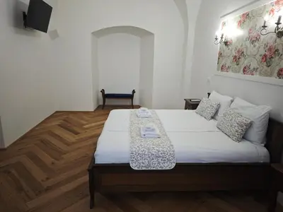 a bedroom with a bed with a table on it at Barbo Palace Apartments and Rooms in Ljubljana