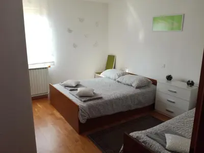 a small bedroom with two beds and a window at Pri Mlinarju in Tolmin