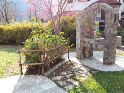 a stone bench sitting in a garden with flowers at Pri Mlinarju in Tolmin