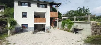 a large white house with a balcony on the side at Apartments Ten Sen in Kobarid