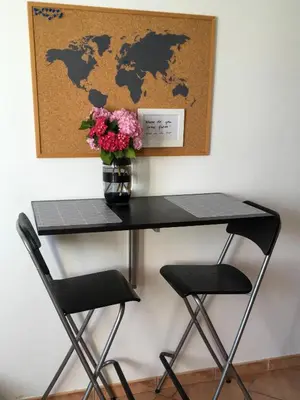 a table with a vase of flowers and two chairs at Apartment Nova Gorica - Nočitve Falco in Nova Gorica
