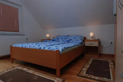 a bedroom with a bed with a blue comforter at Apartments Bernarda in Bled