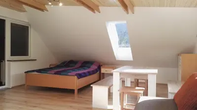 a small room with a bed and a table at Apartments Bernarda in Bled