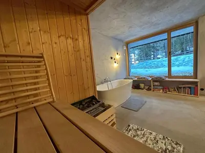 a bathroom with a bed and a tub and a window at Cosy Lodge Pokljuka in Goreljek