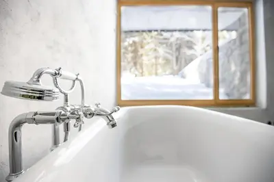 a bathroom sink with a faucet and a window at Cosy Lodge Pokljuka in Goreljek