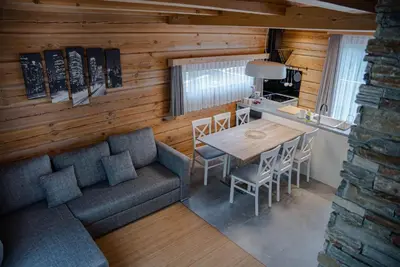 a living room with a couch and a table and a kitchen at ALPEART BOHINJ HOLIDAY units in Bohinj
