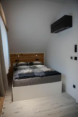 a bedroom with a large bed with a wooden headboard at ALPEART BOHINJ HOLIDAY units in Bohinj