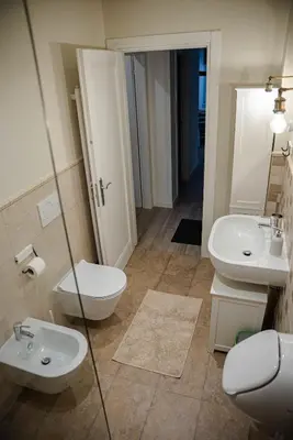 a bathroom with two sinks and a toilet and a mirror at ALPEART BOHINJ HOLIDAY units in Bohinj