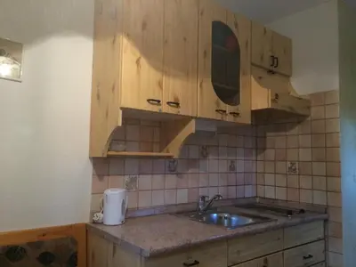 a kitchen with wooden cabinets and a sink at Apartma Gracner in Bled