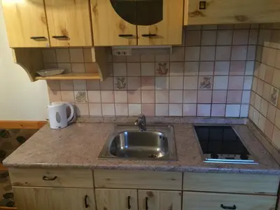 a kitchen with a sink and a tiled wall at Apartma Gracner in Bled