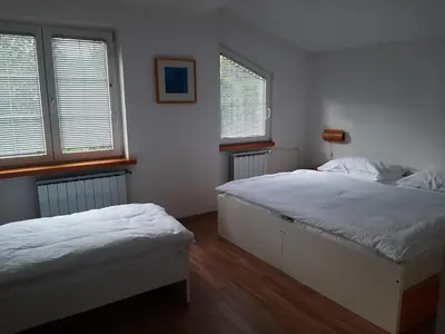 two beds in a room with two windows at Apartment Zupan in Maribor