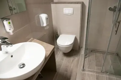 a bathroom with a toilet and a sink and a shower at Hotel Center Novo Mesto in Novo Mesto