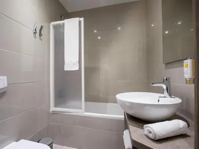 a bathroom with a sink and a shower and a toilet at Hotel Center Novo Mesto in Novo Mesto