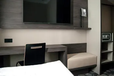 a bedroom with a desk with a chair and a tv at Hotel Center Novo Mesto in Novo Mesto