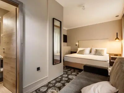 a hotel room with a bed and a mirror at Hotel Center Novo Mesto in Novo Mesto