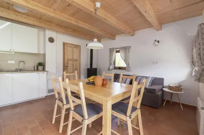 a kitchen and dining room with a wooden table and chairs at Holiday Homes Sara in Bled