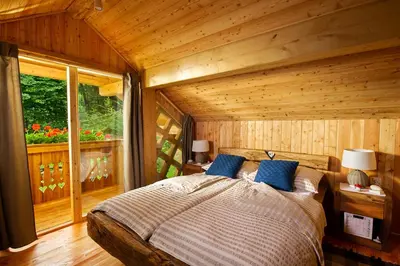 a bedroom with a bed in a log cabin at Glamping Savinja in Ljubno