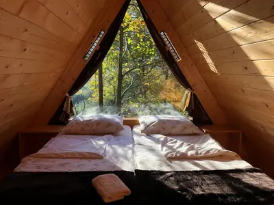 a bed in a tent with a large window at Glamping Savinja in Ljubno