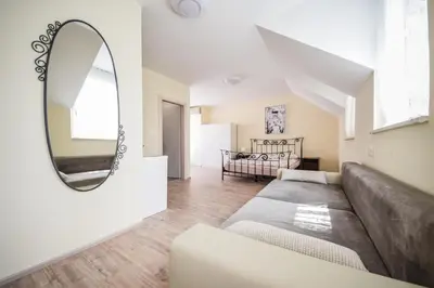 a living room with a couch and a mirror at Apartments Maria in Ljubljana