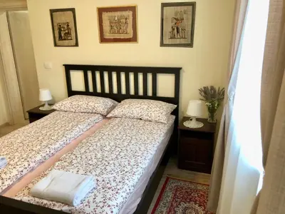 a bedroom with a bed and two tables and two lamps at Apartments Maria in Ljubljana