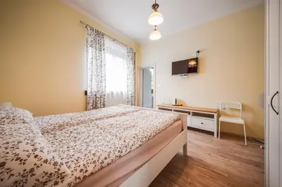 a bedroom with a bed and a desk and a television at Apartments Maria in Ljubljana