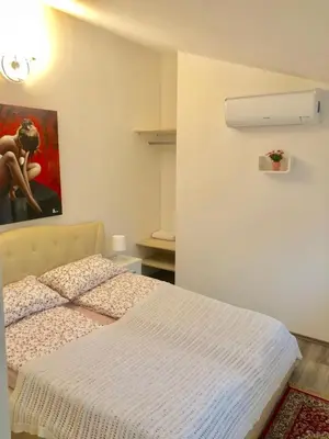 a bedroom with a bed and a painting on the wall at Apartments Maria in Ljubljana