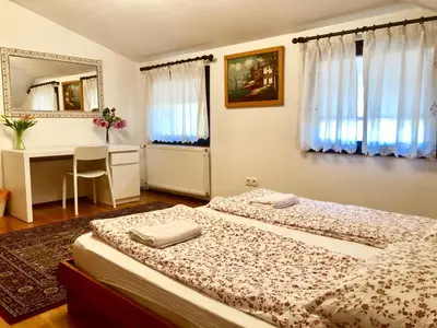 a bedroom with two beds and a desk and a mirror at Apartments Maria in Ljubljana
