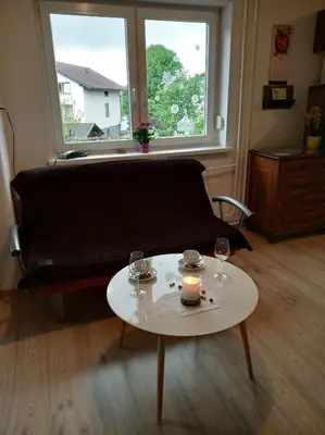 a living room with a couch and a table with two glasses at Apartment Janja in Vojnik