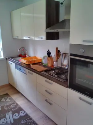 a kitchen with white cabinets and a stove top oven at Apartment Janja in Vojnik