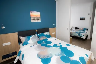 a blue bedroom with a large bed with blue walls at Apartma Grže in Postojna